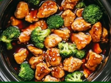 Crockpot Teriyaki Chicken in a bowl garnished with sesame seeds and green onions